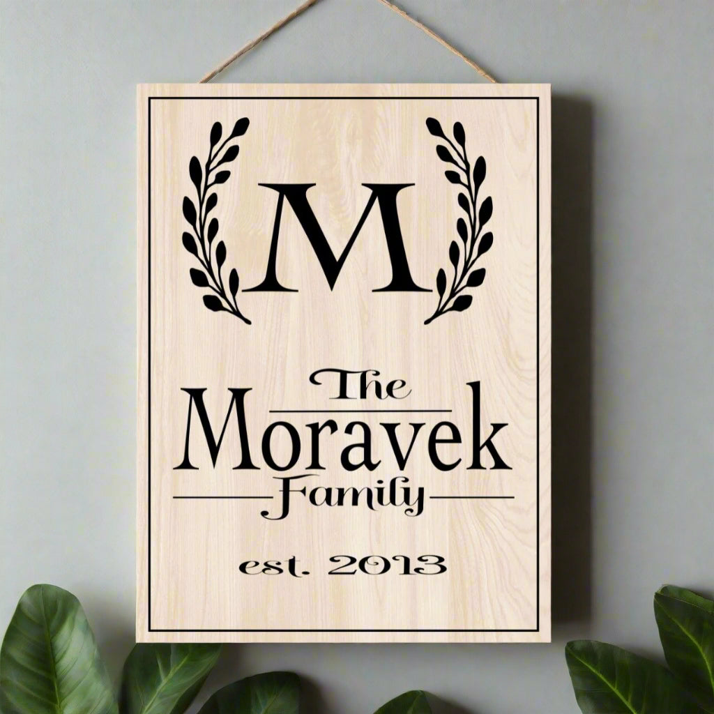 Wooden plaque with 'The Moravek Family est. 2013' engraving on a white background