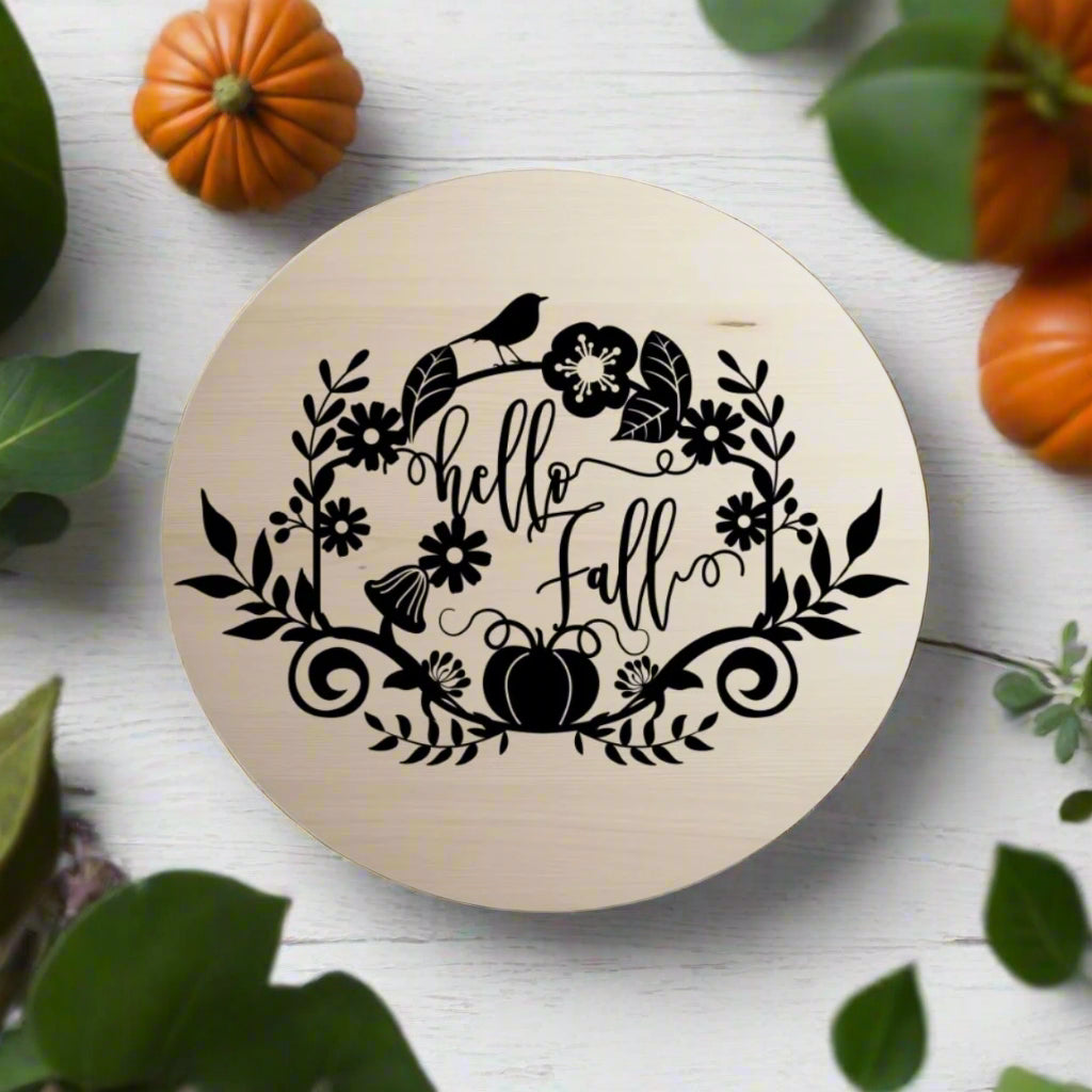 Round wooden coaster with 'hello fall' design featuring leaves, flowers, and a pumpkin on a white background.